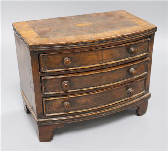 A miniature bow fronted chest of drawers width 27cm height 21cm depth 13cm